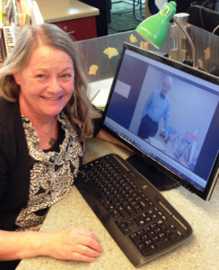 Suzi Worthen at the Lyman Branch Library taking in Gene Gagliano's afternoon keynote address at her desk.