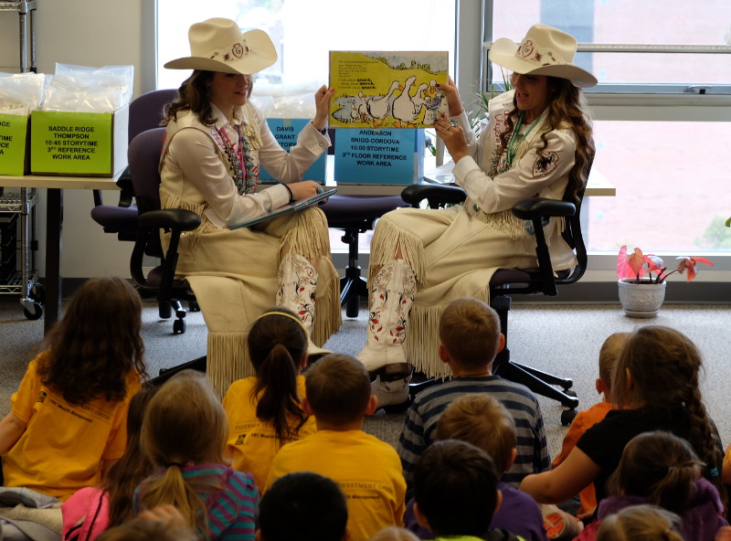 CFD Rodeo Queens Jonna Brown and Rylee Anderson reading together.