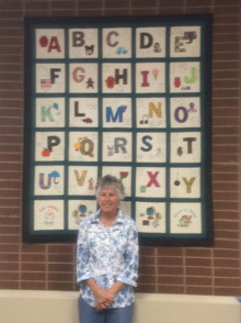 Sue Hurd with the new children’s library quilt.