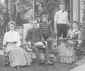 Two women, one man, and two boys posed for an outdoor family portrait in the early 1900s.